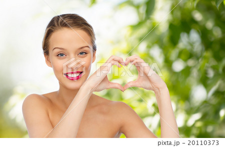 smiling young woman showing heart shape hand sign 20110373