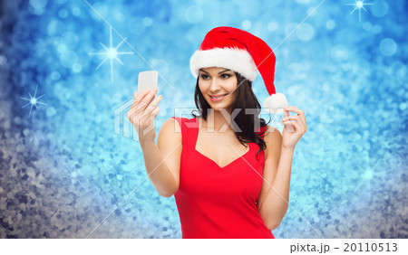 woman in santa hat taking selfie by smartphone woman in santa hat taking selfie by smartphone 20110513