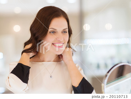 happy woman choosing pendant at jewelry store happy woman choosing pendant at jewelry store 20110713
