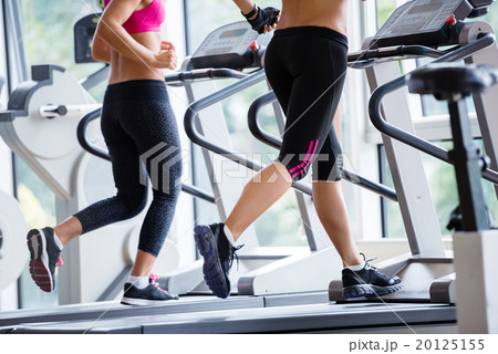 friends exercising on a treadmill at the bright modern gym 20125155