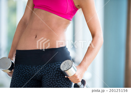 lifting some weights and working on her biceps in a gym 20125156
