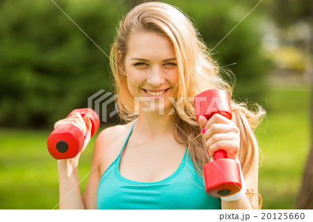 Sports girl exercise with dumbbells in the park 20125660