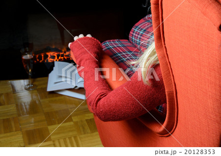 Lady enjoying by the fireplace Lady enjoying by the fireplace 20128353