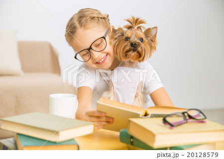Little girl is reading with her dog. Little girl is reading with her dog. 20128579