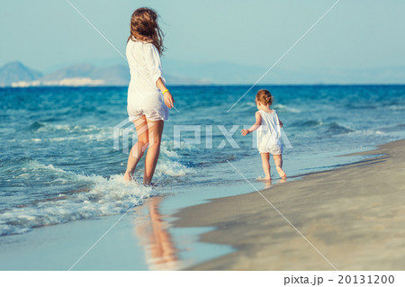 Mother and daughter walking on the beach Mother and daughter walking on the beach 20131200