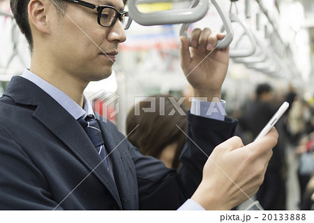 電車内でスマホを操作する男性 ビジネスマンの写真素材 1338