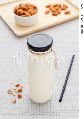 Almond milk in bottle with almonds on table Almond milk in bottle with almonds on table 20134904
