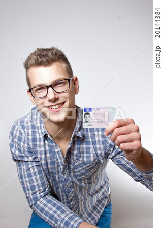 Young man showing off his driver license Young man showing off his driver license 20144384