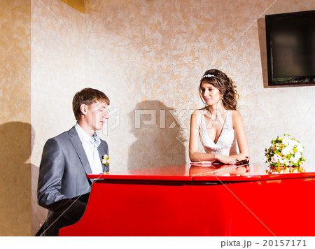 charming wedding couple playing on a red piano in 20157171