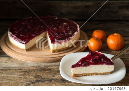 Piece of cheesecake with mandarins on wood table. Piece of cheesecake with mandarins on wood table. 20167063
