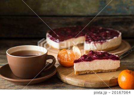 Slice of cheesecake with cherries and cup of tea 20167064