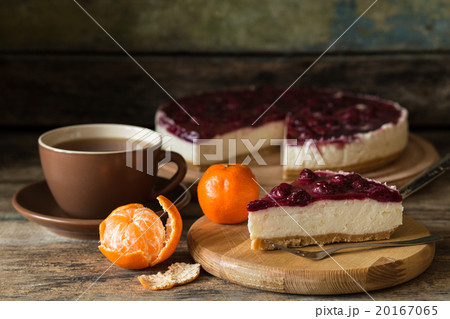 Slice of cheesecake with cherries and cup of tea 20167065