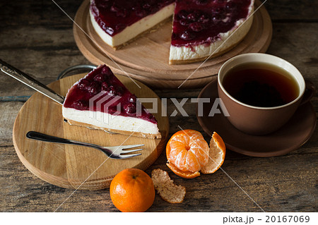 Slice of cheesecake with cherries and cup of tea 20167069