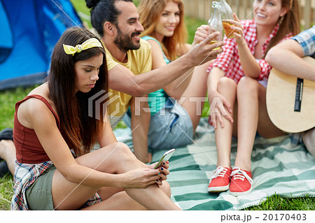 young woman with smartphone and friends at camping 20170403