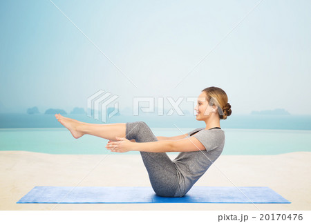 woman making yoga in half-boat pose on mat 20170476