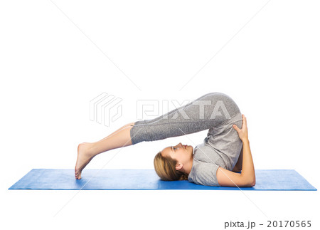 woman making yoga in plow pose on mat 20170565