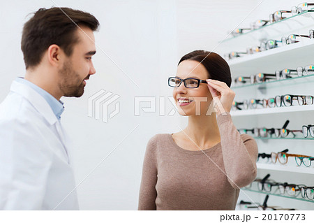 woman choosing glasses at optics store 20170773