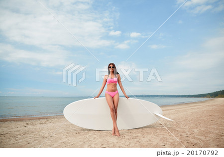 smiling young woman with surfboard on beach smiling young woman with surfboard on beach 20170792
