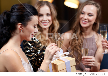 happy women with champagne and gift at night club happy women with champagne and gift at night club 20170824
