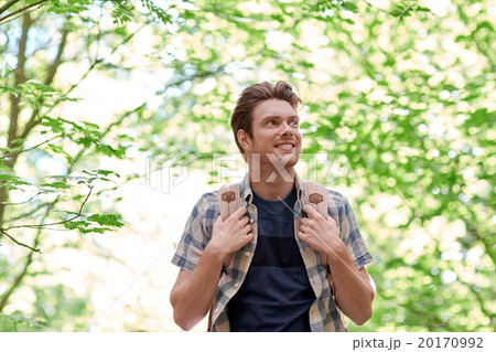 smiling young man with backpack hiking in woods smiling young man with backpack hiking in woods 20170992