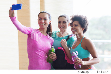 happy women with smartphone taking selfie in gym 20171582