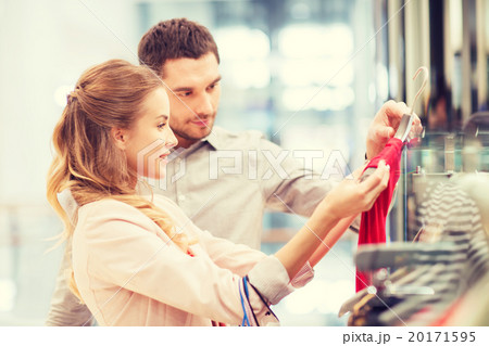happy young couple choosing dress in mall happy young couple choosing dress in mall 20171595