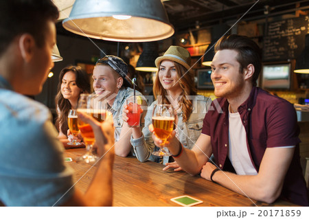 happy friends with drinks talking at bar or pub 20171859