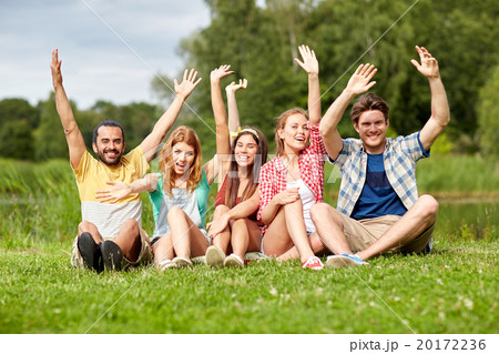 group of smiling friends waving hands outdoors 20172236