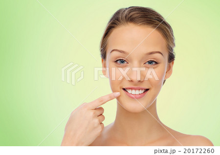 happy young woman pointing finger to her teeth happy young woman pointing finger to her teeth 20172260
