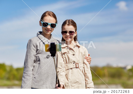 happy girls with smartphone selfie stick 20172263