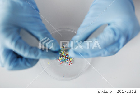 close up of scientist hands holding pill in lab 20172352