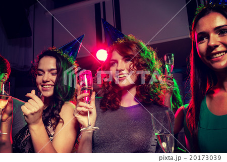 smiling friends with glasses of champagne in club smiling friends with glasses of champagne in club 20173039