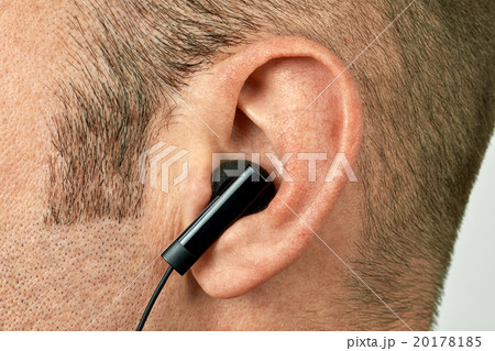 Ear with earphone closeup 20178185