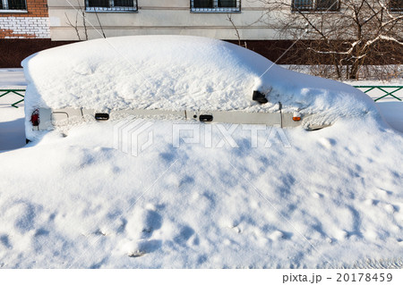 white car covered with snow in parking lot 20178459