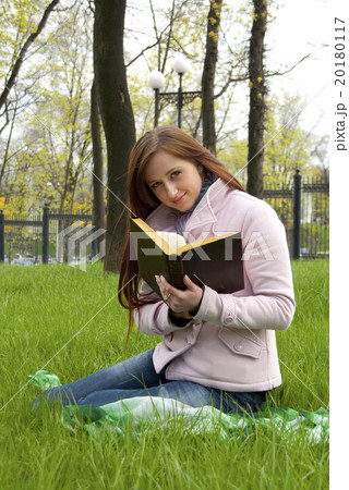 Beautiful redhead woman reading book on a meadow 20180117