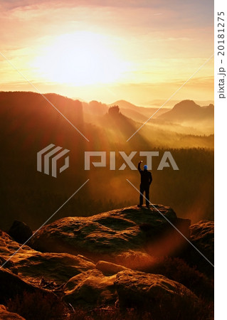 Tourist takes photo with smart phone on cliff edge Tourist takes photo with smart phone on cliff edge 20181275