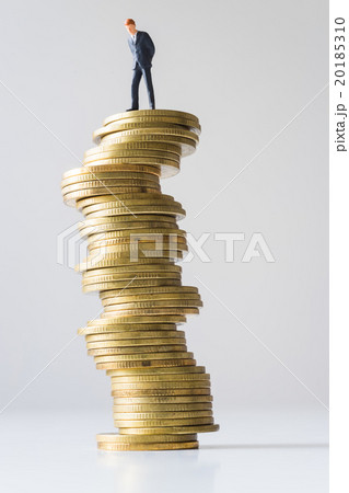 Businessman standing on risky coin stack. 20185310