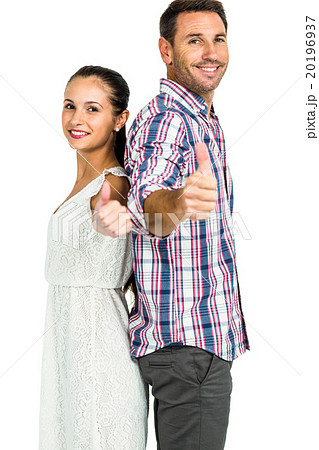 Smiling couple standing back to back showing thumbs up Smiling couple standing back to back showing thumbs up 20196937