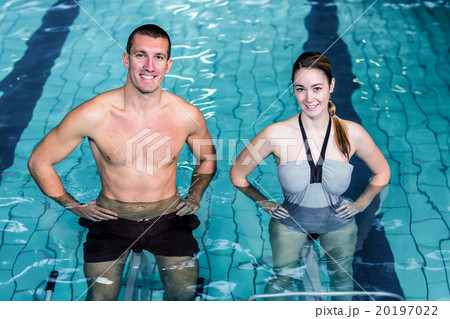 Smiling couple doing aqua aerobics  20197022