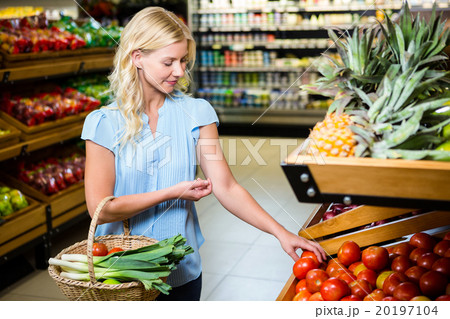 Blonde woman taking tomatoes Blonde woman taking tomatoes 20197104