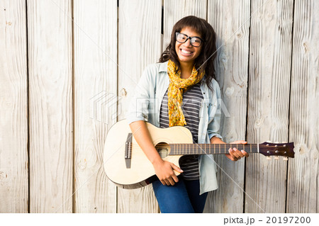 Smiling casual woman playing guitar 20197200