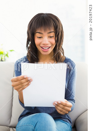 Casual smiling woman reading paper 20197423