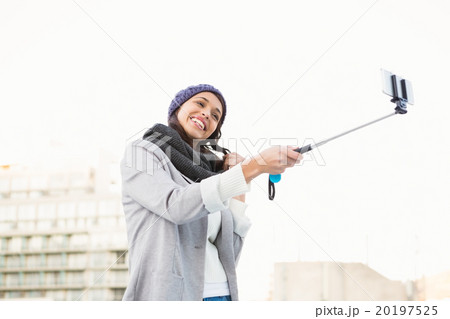 Happy woman using selfie stick Happy woman using selfie stick 20197525