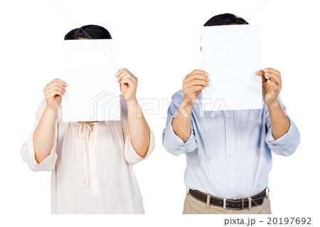 Couple holding pages over faces 20197692