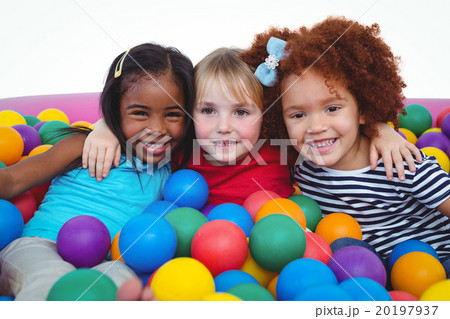 Cute smiling girls in sponge ball pool hugging 20197937