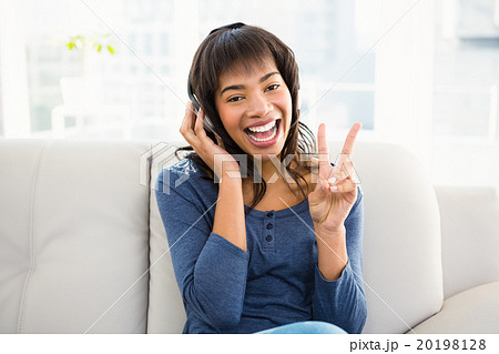 Casual smiling woman listening music with headphones 20198128