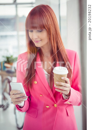 Hipster businesswoman holding coffee cup and smartphone Hipster businesswoman holding coffee cup and smartphone 20198232