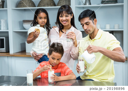 Happy family eating biscuits and drinking milk 20198896