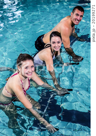 Fitness class doing aqua aerobics on exercise bikes Fitness class doing aqua aerobics on exercise bikes 20199271