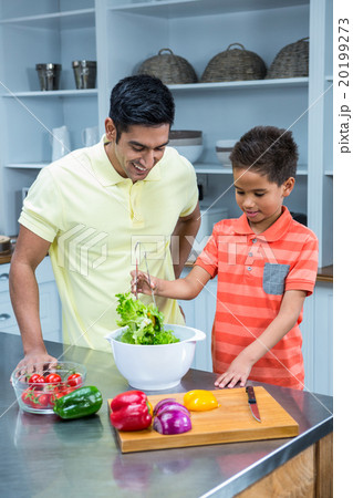 Smiling father preparing salad with his son Smiling father preparing salad with his son 20199273